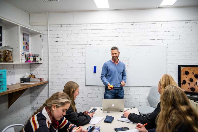 Photo of Rob Mages, Clever Cookie Academy co-founder, teaching a classroom of high school students.
